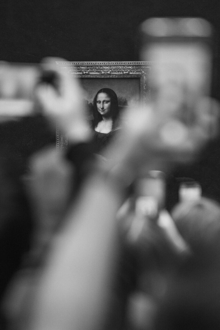Ein gerahmtes Porträt der Mona Lisa wird in Schwarz-Weiß durch unscharfe Hände im Vordergrund betrachtet, die Geräte halten.
