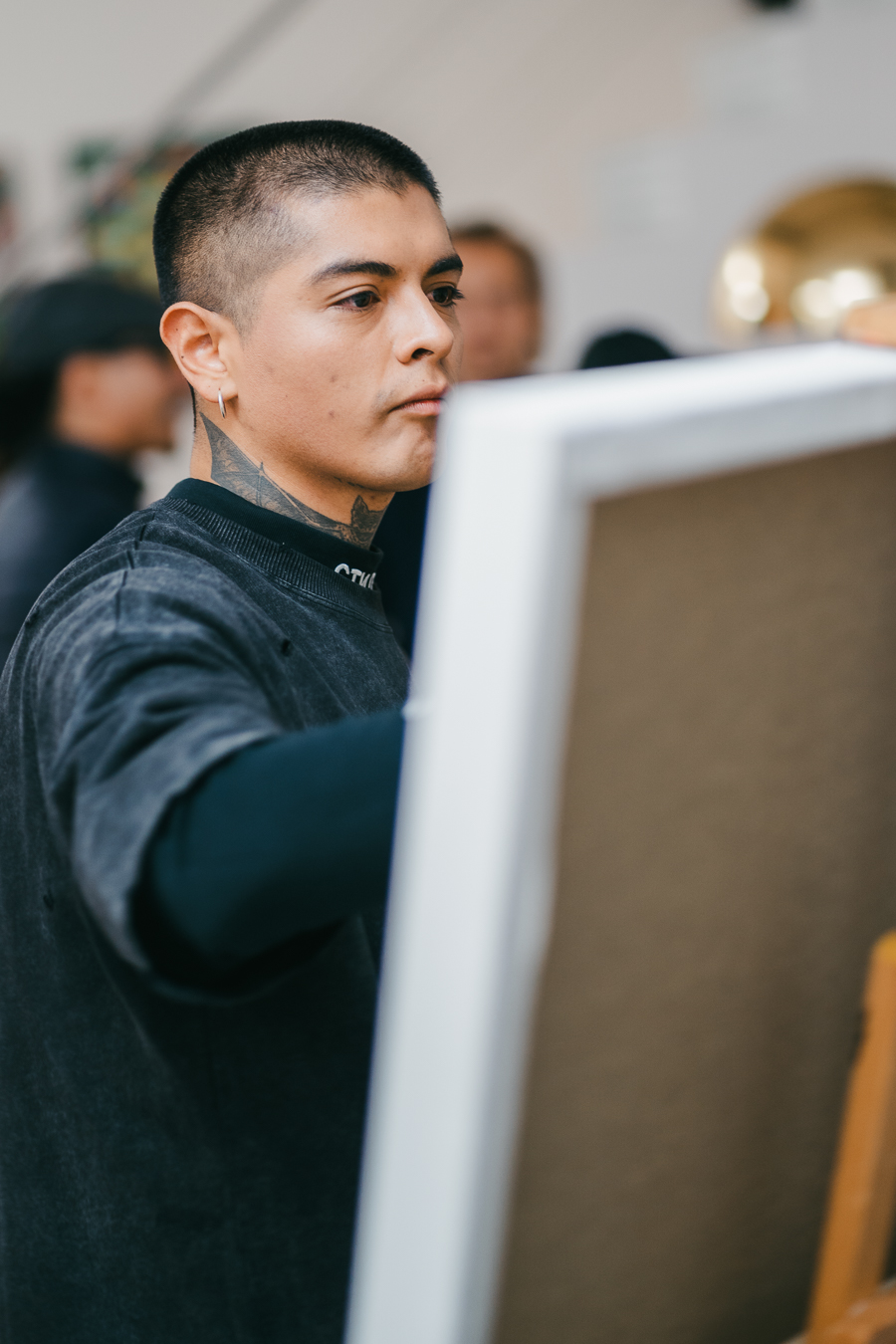 A man works on a canvas on an easel.