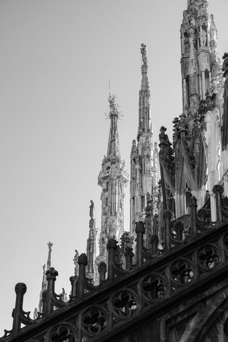 Monochrome view of the intricate spires and Gothic architectural details of Milan Cathedral.