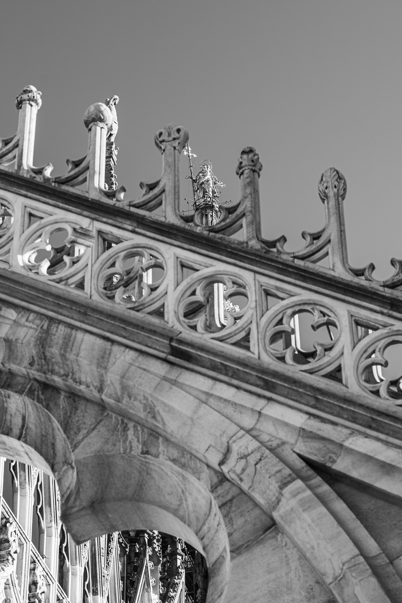 Monochrome Untersicht der detaillierten gotischen Steinmaßwerke und Fialen des Mailänder Doms.